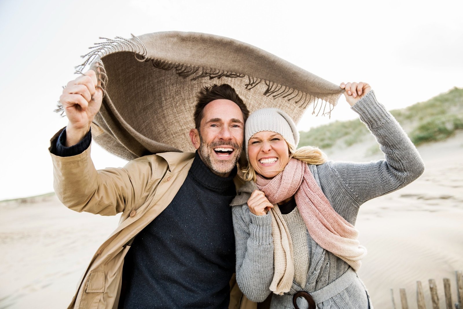 Couple souriant sur une plage, illustrant un projet personnel
